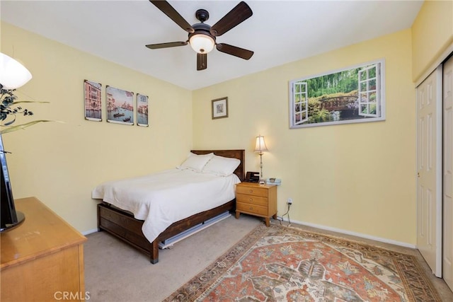 bedroom with light carpet, ceiling fan, and a closet