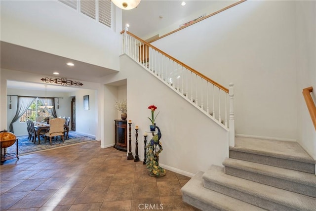 stairway featuring a towering ceiling and tile patterned flooring