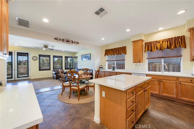 kitchen featuring ceiling fan, sink, dark tile patterned floors, and a center island