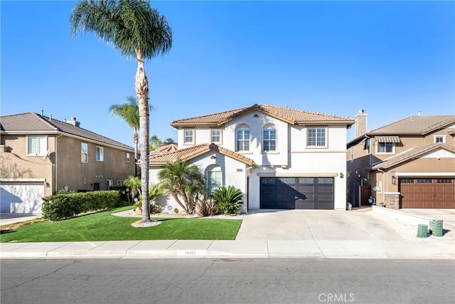 mediterranean / spanish home featuring a front yard and a garage