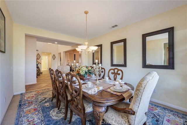 tiled dining room featuring a notable chandelier