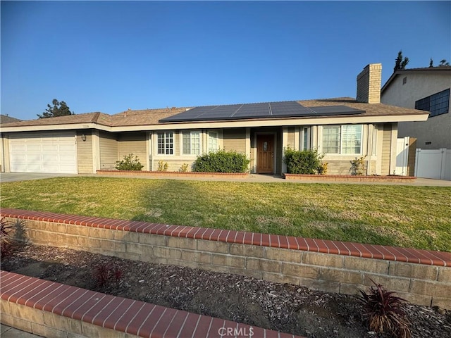 ranch-style house with a garage, a front lawn, and solar panels