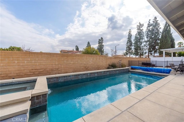 view of swimming pool featuring an in ground hot tub and a patio area