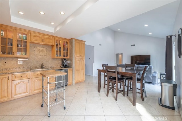 kitchen with sink, light stone counters, light tile patterned floors, dishwasher, and backsplash