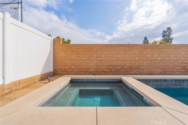 view of swimming pool featuring an in ground hot tub