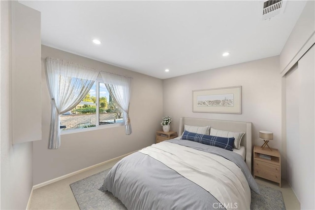 bedroom featuring light colored carpet and a closet