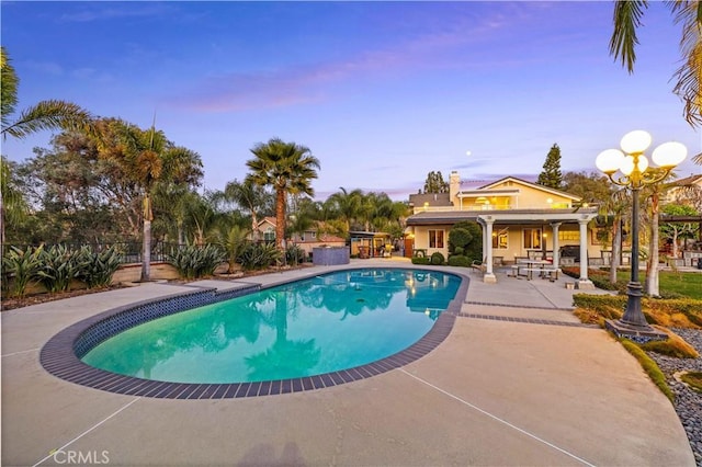 pool at dusk with a patio