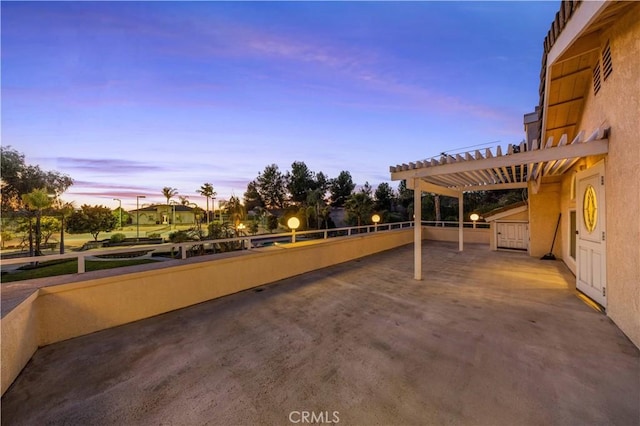 patio terrace at dusk featuring a pergola