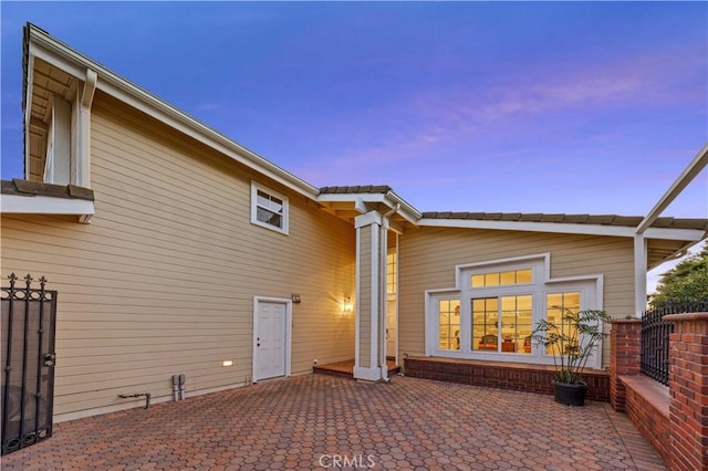 back house at dusk with a patio