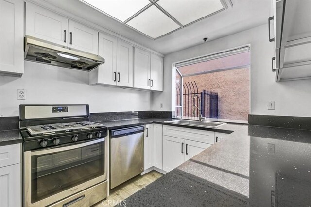 kitchen featuring white cabinets, sink, stainless steel appliances, and light hardwood / wood-style floors