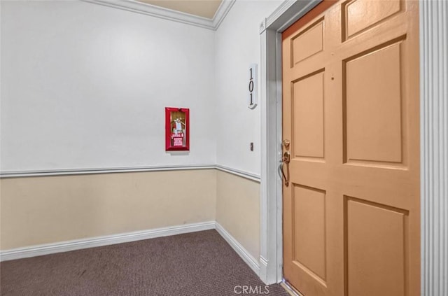 interior space featuring ornamental molding and dark carpet