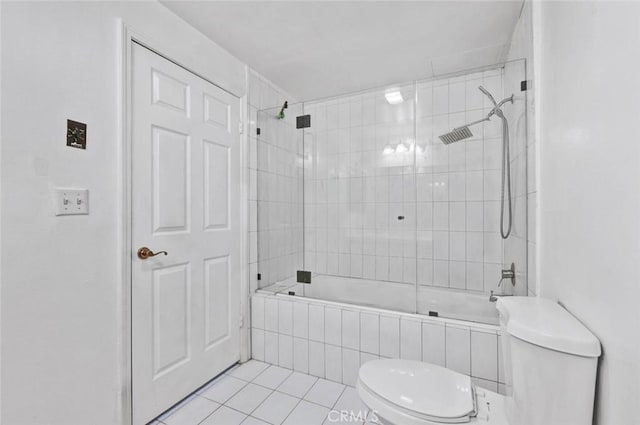 bathroom featuring toilet, tiled shower / bath, and tile patterned floors