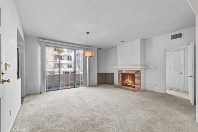 unfurnished living room featuring light carpet and a tile fireplace