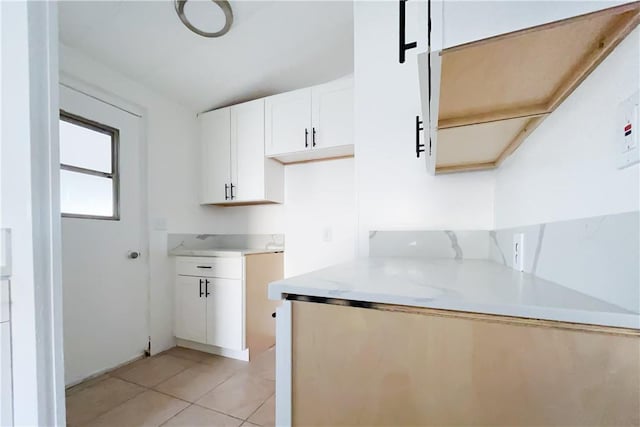 kitchen featuring light tile patterned flooring and white cabinetry