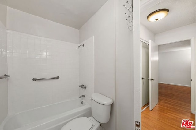 bathroom with toilet, shower / bath combination, and wood-type flooring