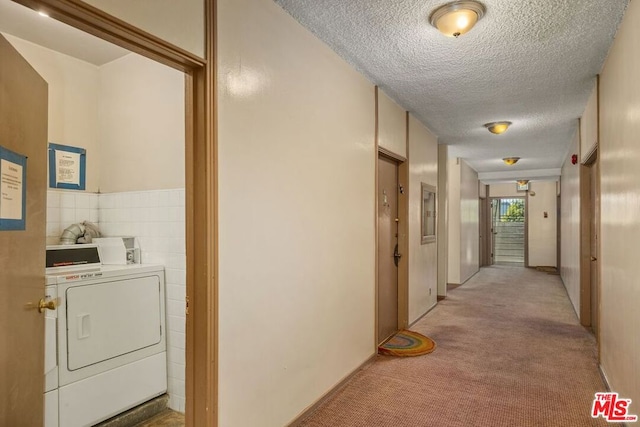 hallway with light carpet and a textured ceiling