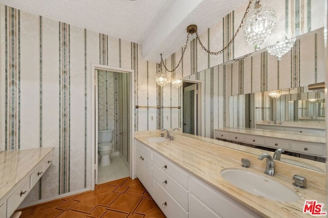 bathroom with a textured ceiling, toilet, vanity, and a notable chandelier