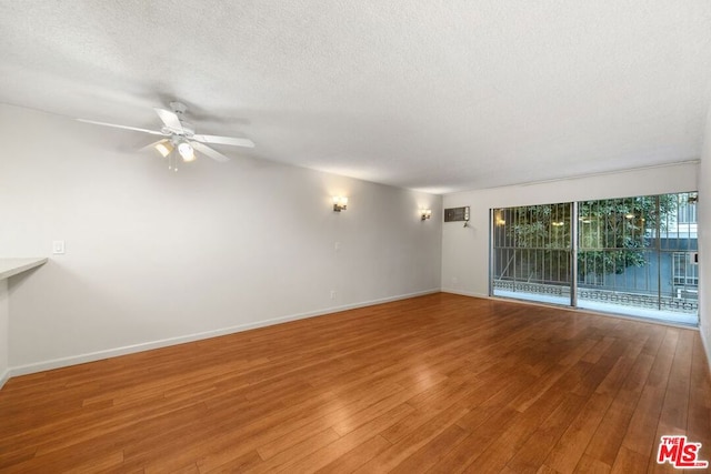 empty room featuring ceiling fan, hardwood / wood-style floors, and a textured ceiling