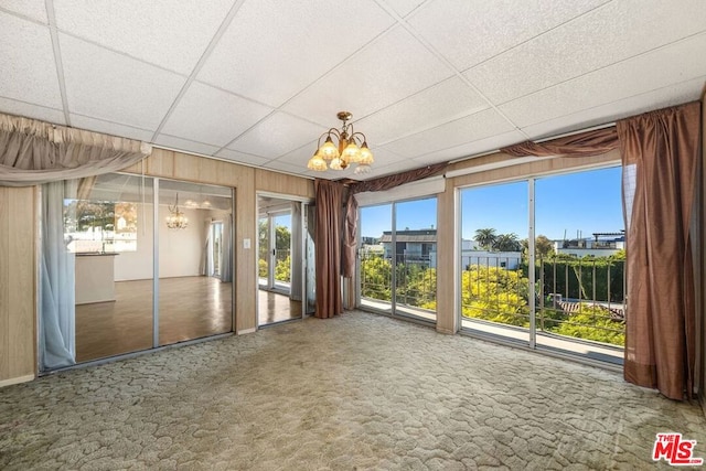 unfurnished sunroom with an inviting chandelier and a paneled ceiling