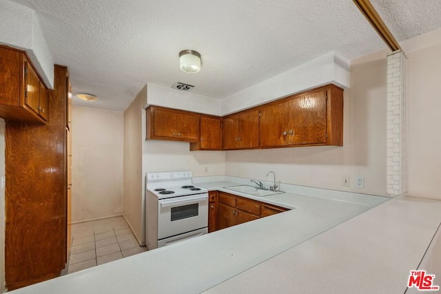 kitchen with white range with electric cooktop, sink, light tile patterned floors, and a textured ceiling