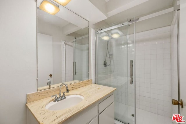 bathroom featuring vanity and a shower with door