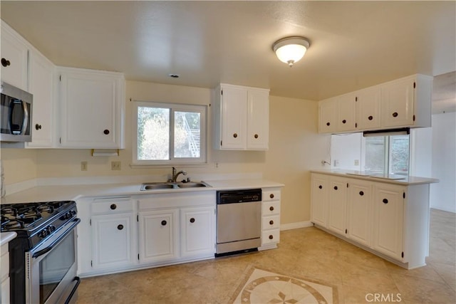 kitchen with sink, white cabinetry, light tile patterned floors, and stainless steel appliances