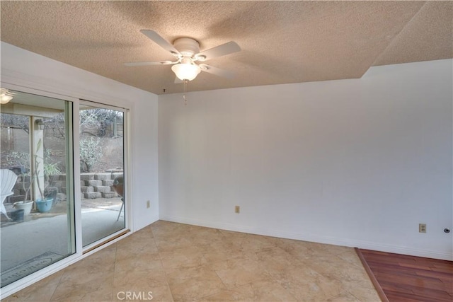 empty room with ceiling fan and a textured ceiling