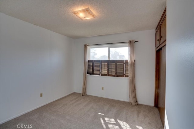 carpeted spare room with a textured ceiling