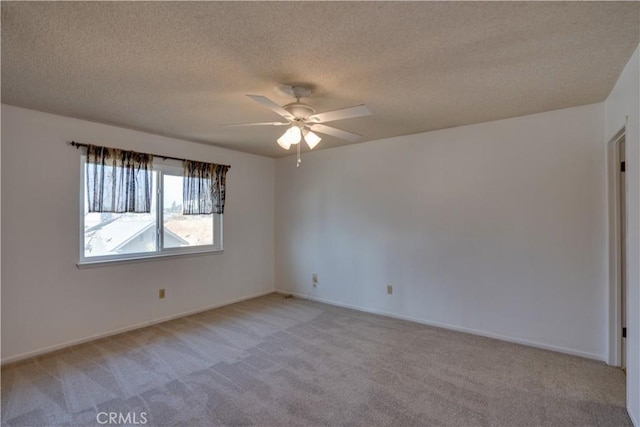 empty room featuring a textured ceiling, ceiling fan, and light colored carpet