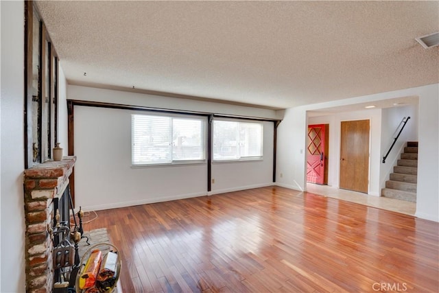 unfurnished living room featuring a textured ceiling and hardwood / wood-style flooring