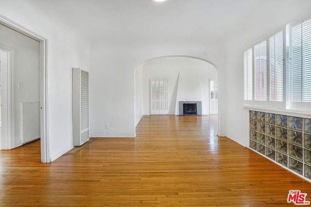 unfurnished living room featuring a large fireplace and light hardwood / wood-style flooring