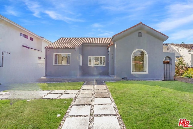 mediterranean / spanish-style house with a front lawn and a patio