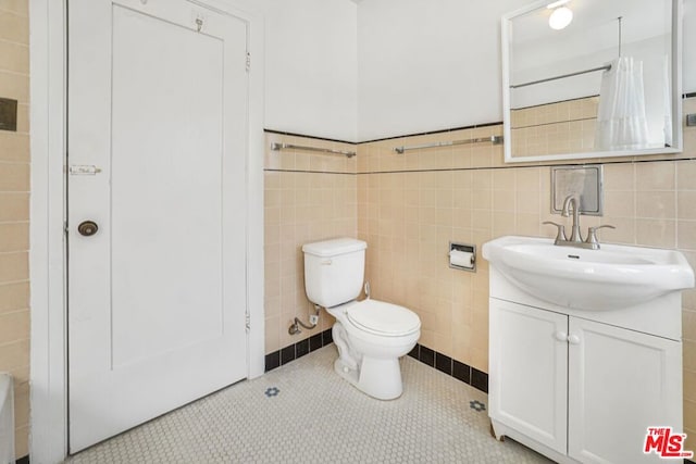 bathroom featuring tile patterned flooring, vanity, tile walls, and toilet