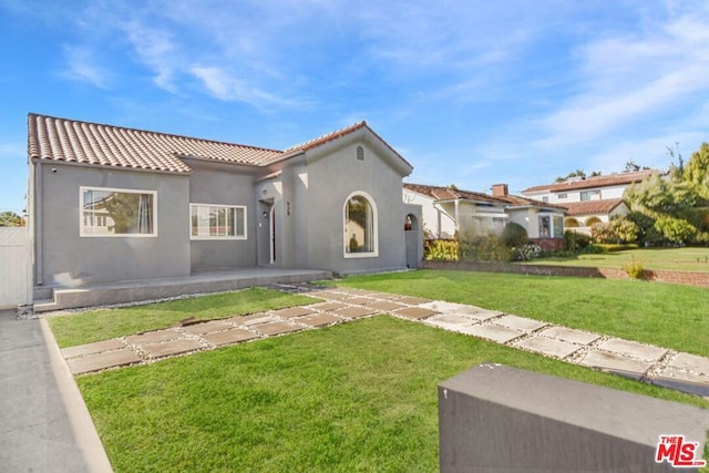 mediterranean / spanish home with a front yard and a patio area