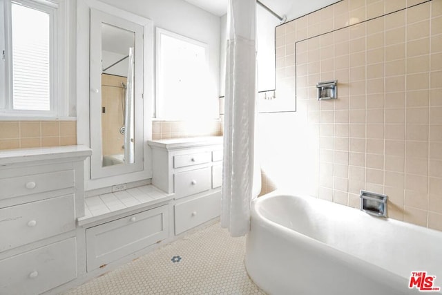 bathroom featuring shower / bathtub combination with curtain and tile patterned flooring