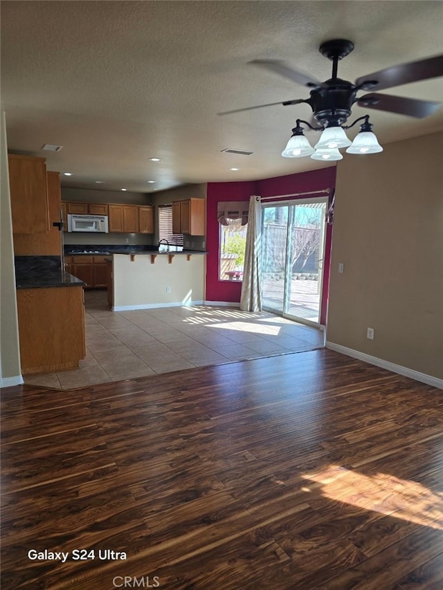 unfurnished living room featuring ceiling fan and light wood-type flooring