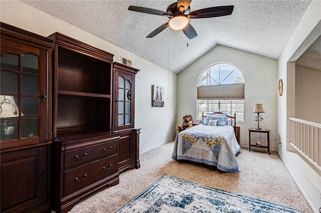 bedroom with lofted ceiling, a textured ceiling, ceiling fan, and light carpet