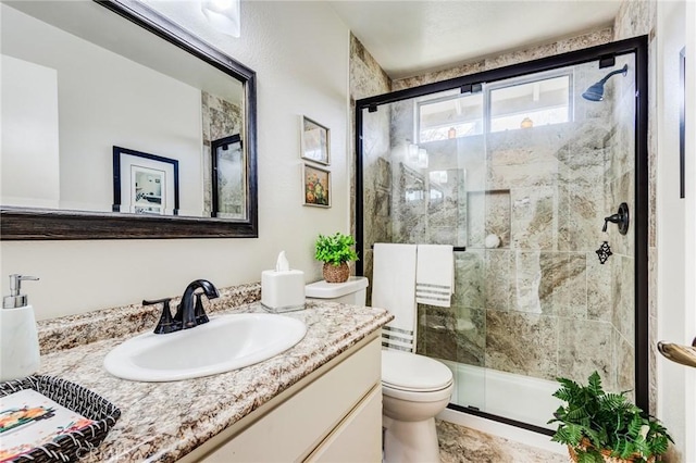 bathroom with toilet, a stall shower, and vanity