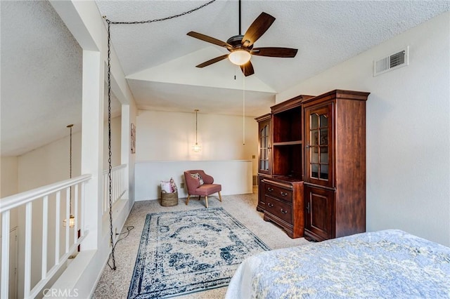 bedroom featuring a textured ceiling, visible vents, a ceiling fan, light carpet, and vaulted ceiling