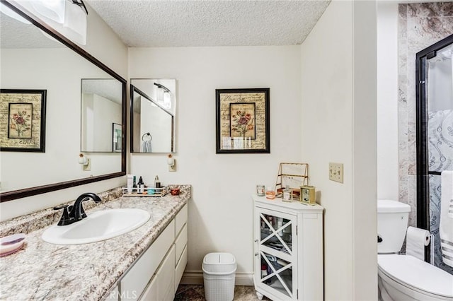 full bath featuring a textured ceiling, toilet, walk in shower, and vanity