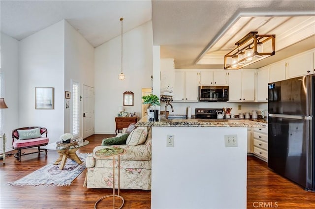 kitchen with dark wood-style floors, stone countertops, pendant lighting, a peninsula, and black appliances