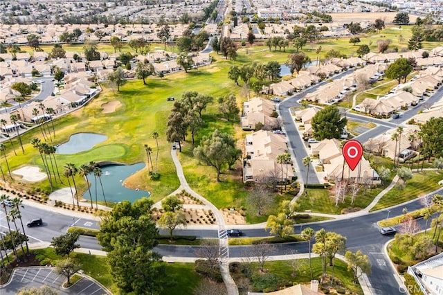 drone / aerial view with a residential view, golf course view, and a water view