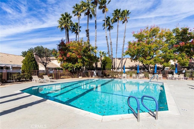 community pool featuring fence and a patio area
