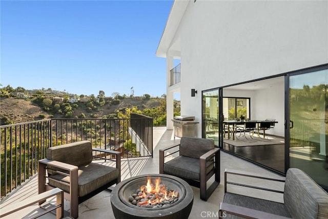 balcony featuring an outdoor fire pit