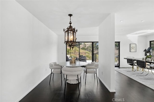 dining space featuring dark hardwood / wood-style floors and a notable chandelier