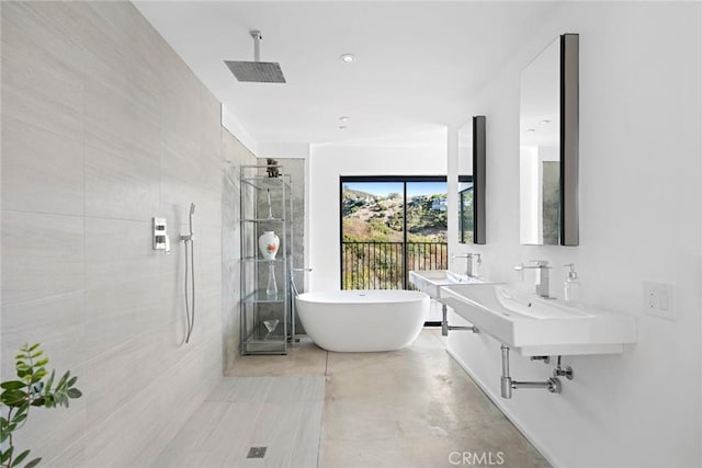 bathroom with sink, concrete floors, and separate shower and tub