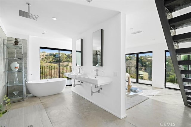 bathroom with sink, concrete floors, and shower with separate bathtub