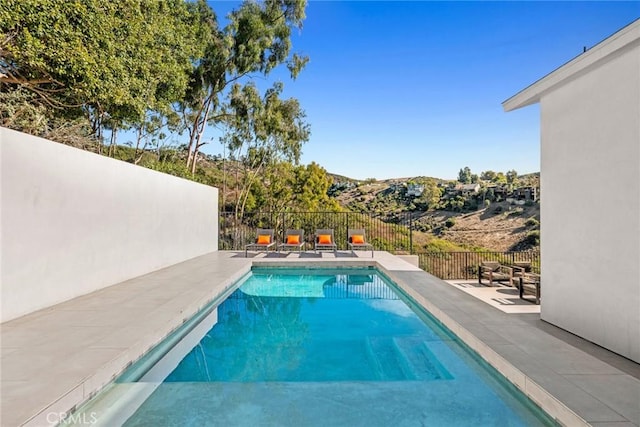 view of swimming pool featuring a mountain view and a patio