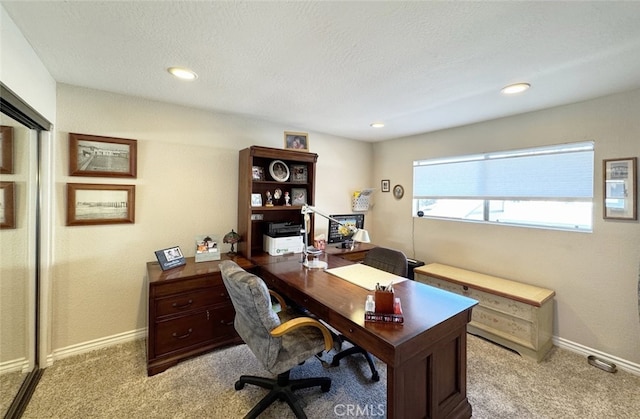 carpeted office with a textured ceiling