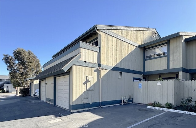 view of property exterior with a garage and a balcony